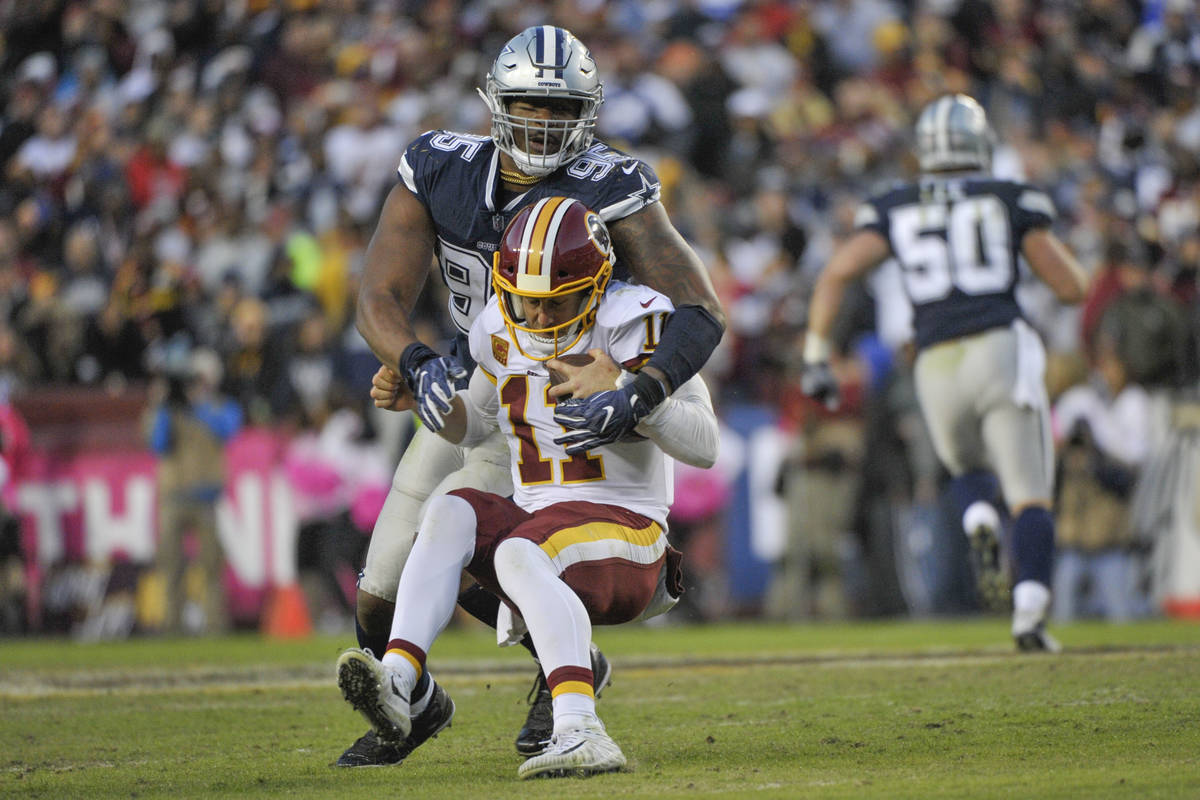 Washington Redskins quarterback Alex Smith (11) is sacked by Dallas Cowboys defensive tackle Da ...