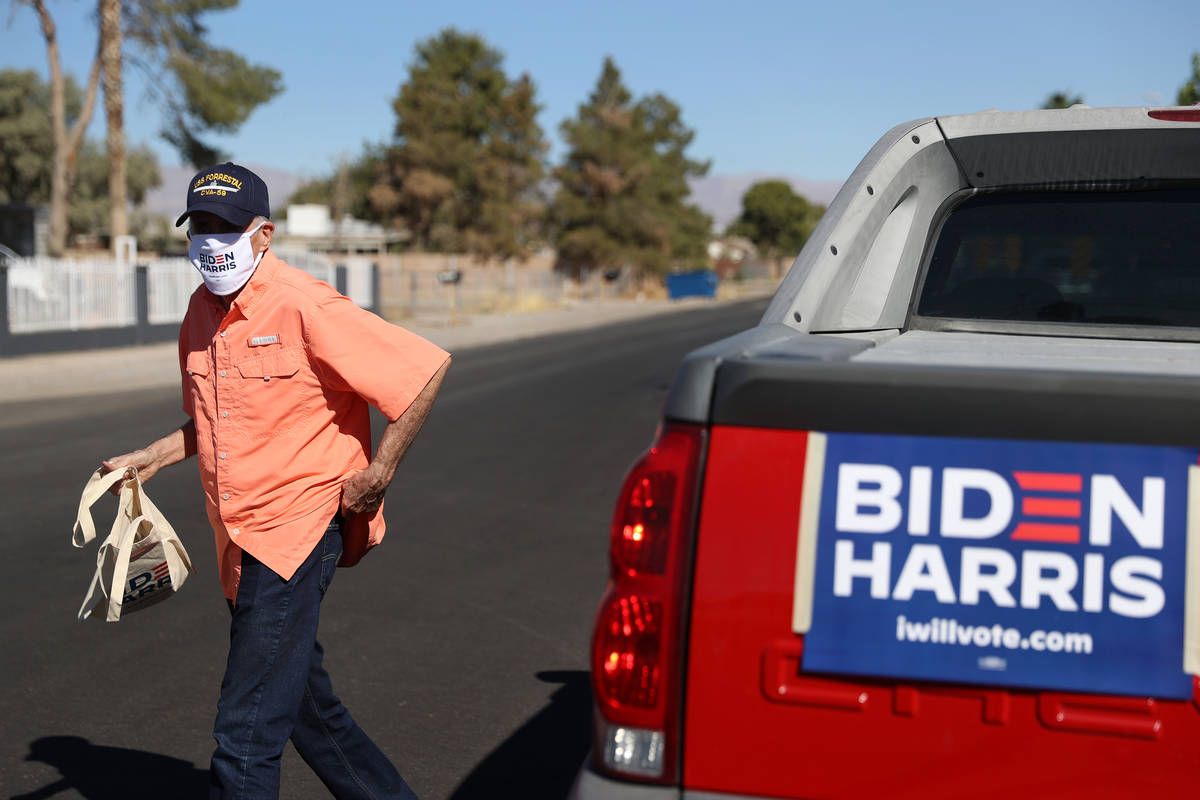 Canvasser Peter Ward of North Las Vegas walks from his car to drop off literature at the home o ...