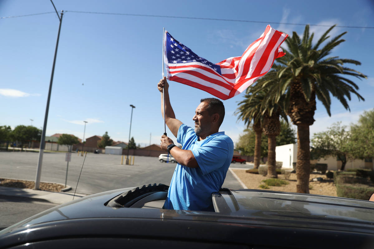 Juan Prillwitz waves an American flag while participating during a campaign parade for Assembly ...