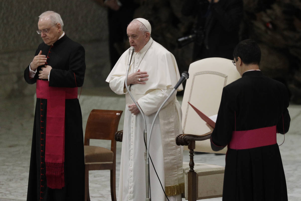 Pope Francis, center, makes the sign of the cross during his weekly general audience in the Pau ...