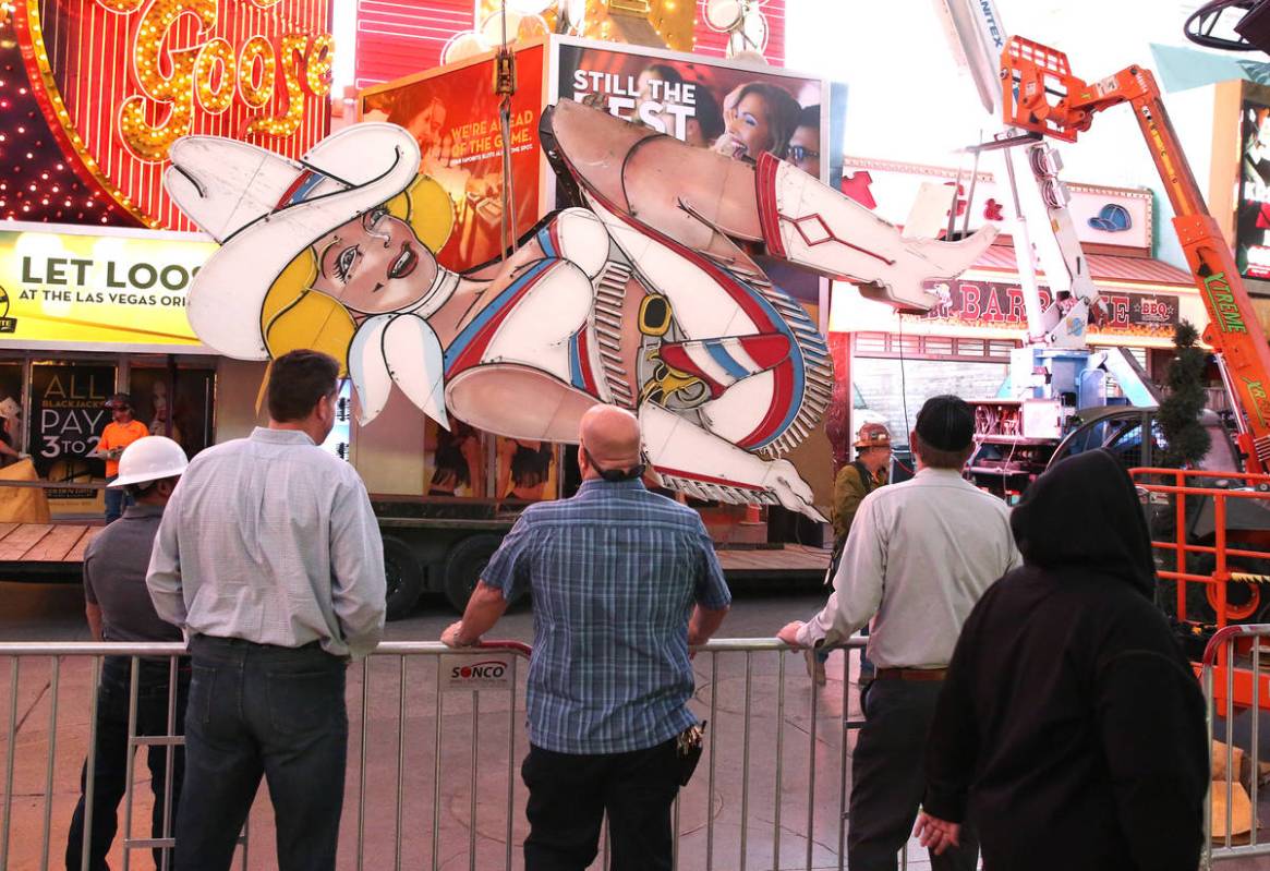 People watch as workers remove the high-kicking Vegas Vickie on Fremont Street on Tuesday, June ...
