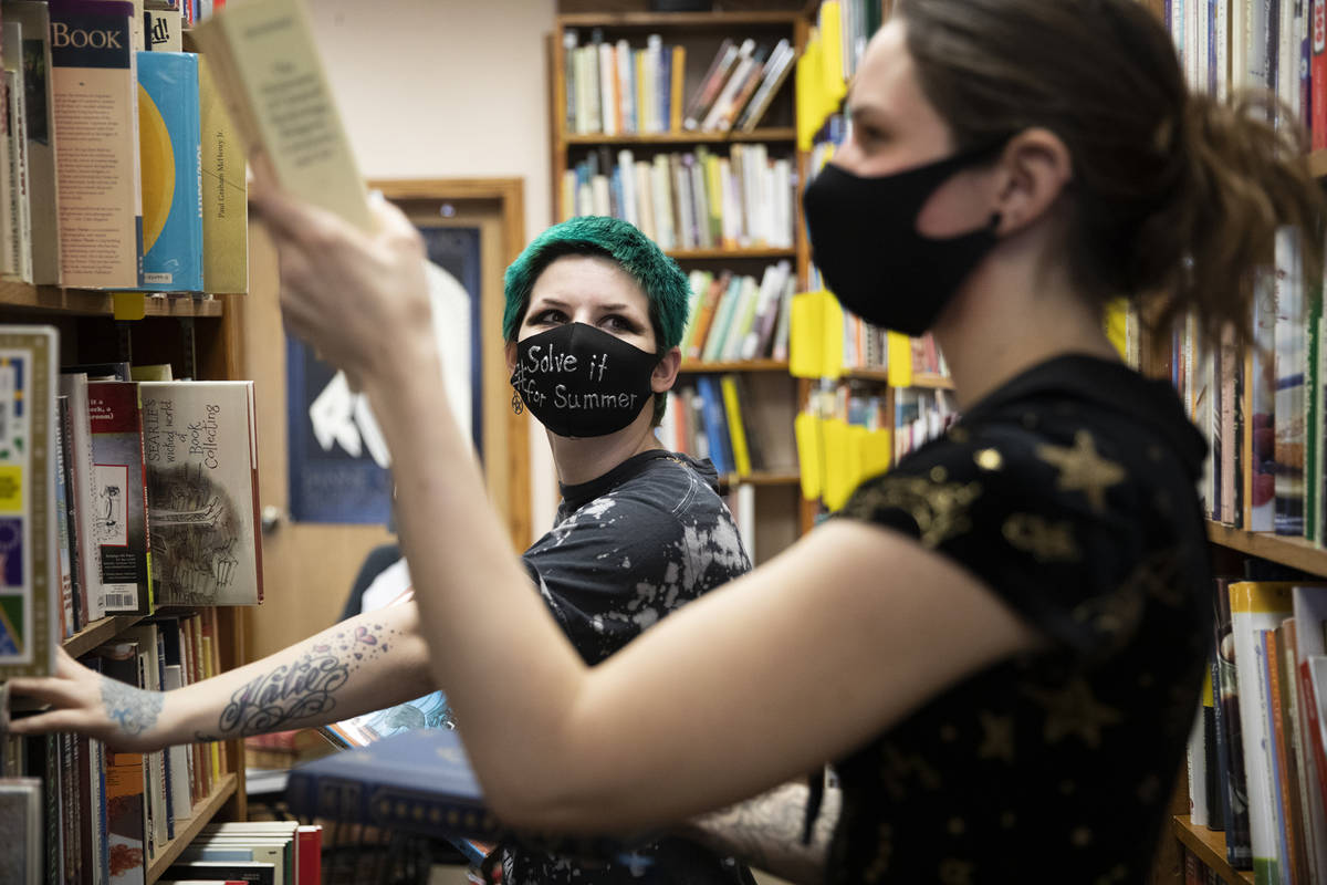 Friends Mercury Taft, left, and Stephanie Lehr, right, shop for books at Amber Unicorn Books in ...