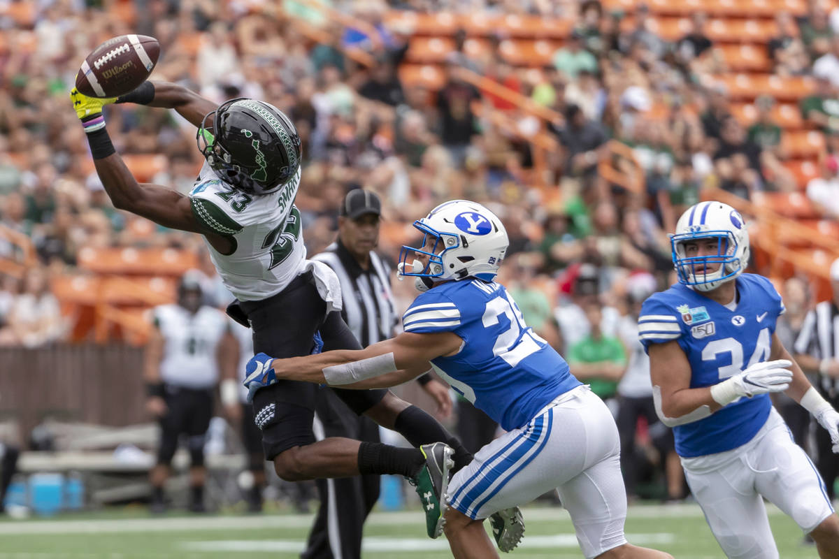 The football is just out of reach of Hawaii wide receiver Jared Smart (23) as BYU defensive bac ...