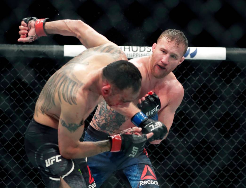 In this May 10, 2020, file photo, Tony Ferguson, left, falls backward after taking a punch from ...