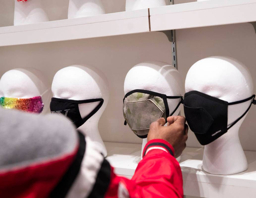 Costa Collins, of Atlanta, checks out a mask for sale at the COVID-19 Essentials store in the F ...