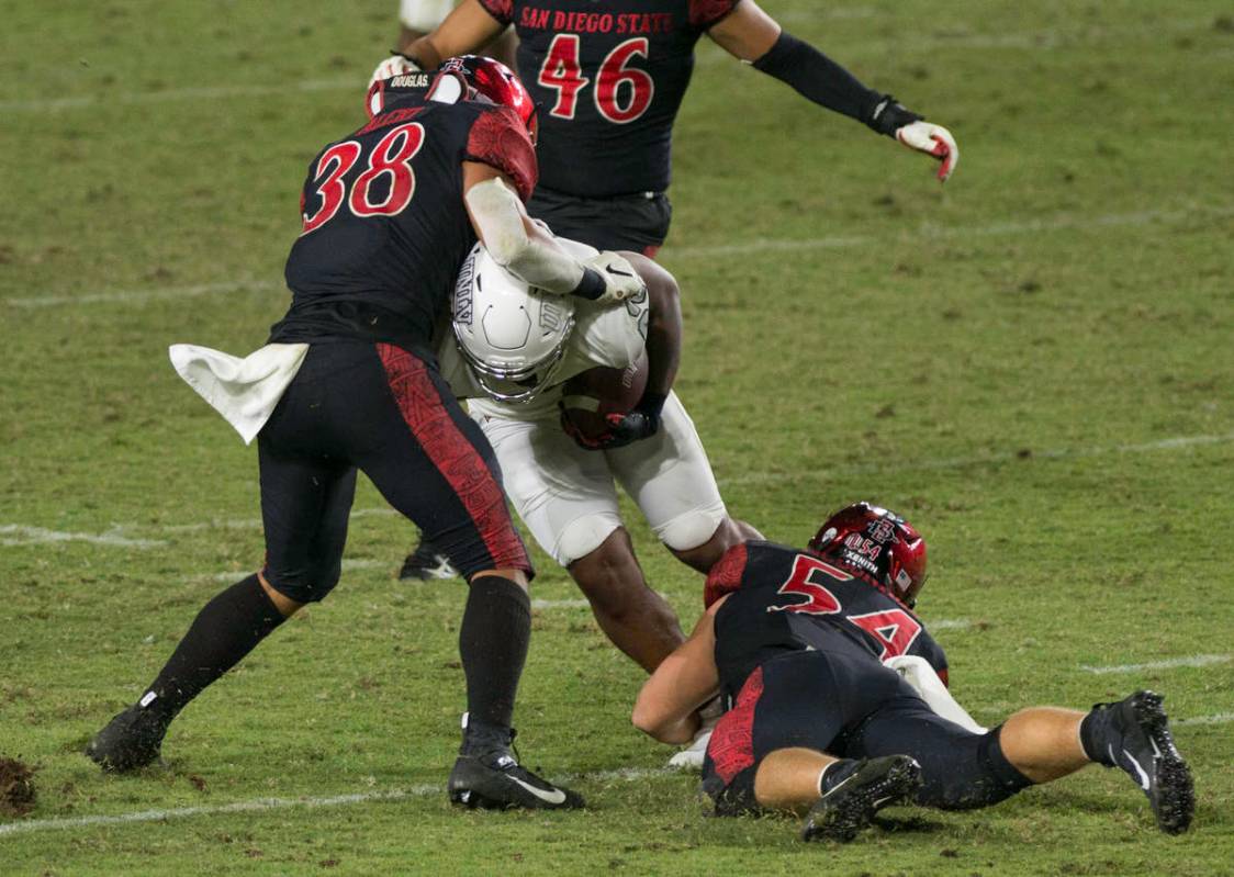 San Diego State’s Andrew Aleki (38) and Caden McDonald tackle UNLV’s Dylan Downing during S ...