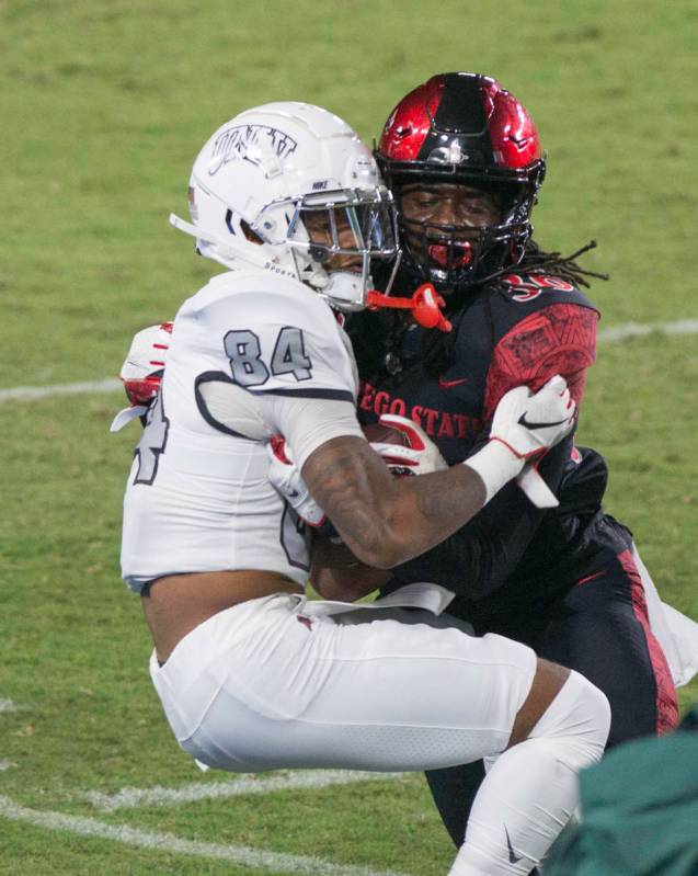 UNLV’s Steve Jenkins is tackled by San Diego State’s Dwayne Johnson Jr. during Saturday's M ...