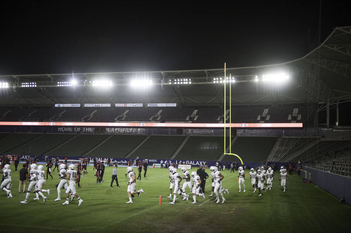 The UNLV Rebels take the field to warm up under the light of a near empty stadium before the st ...
