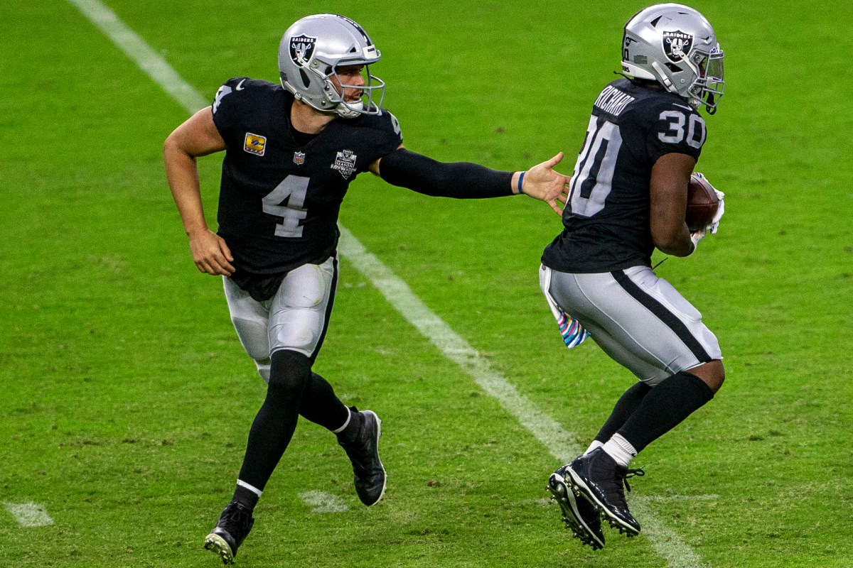 Las Vegas Raiders quarterback Derek Carr (4) hands off the football to running back Jalen Richa ...