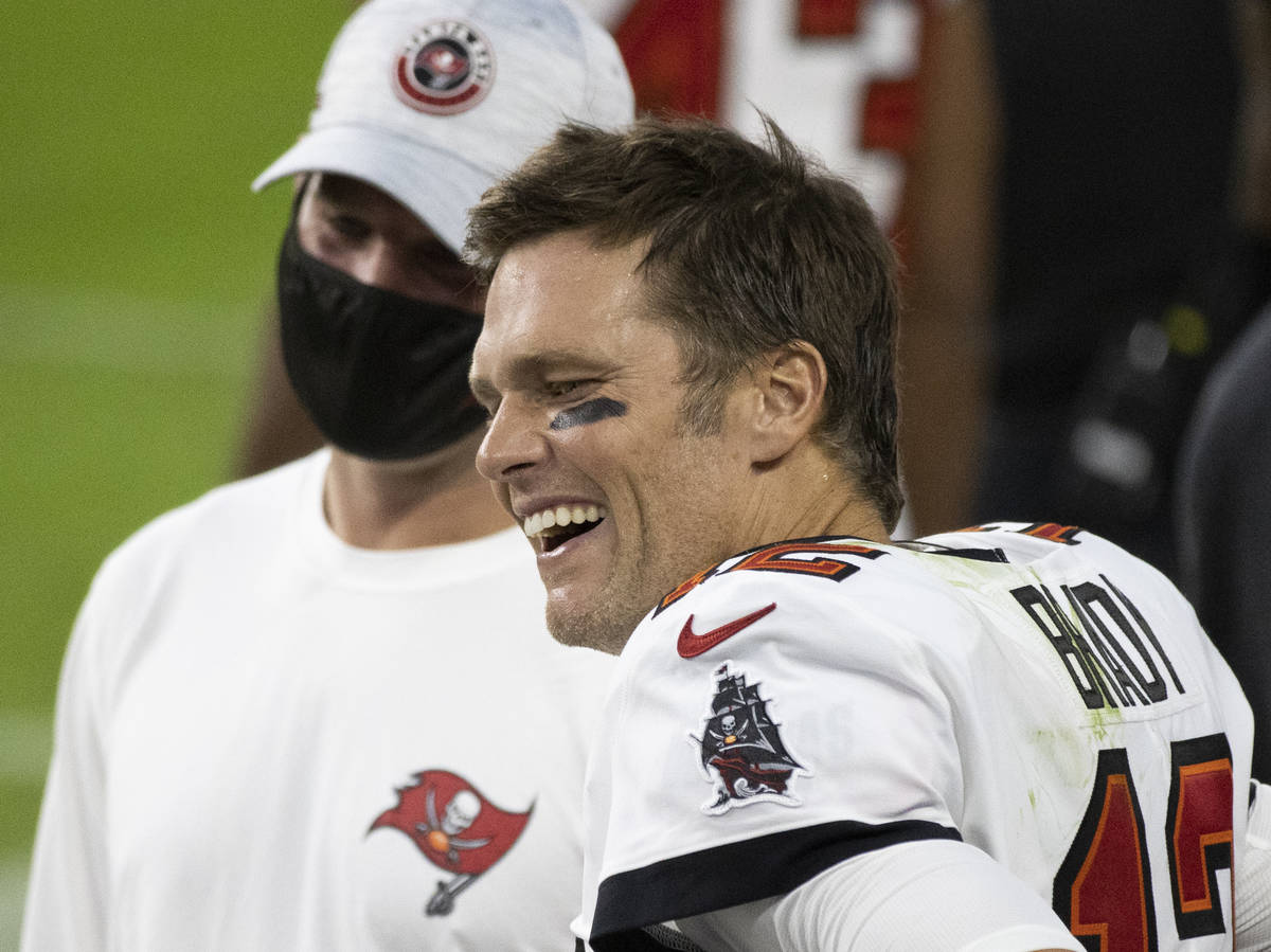 Tampa Bay Buccaneers quarterback Tom Brady (12) shares a laugh with teammates in the fourth qua ...
