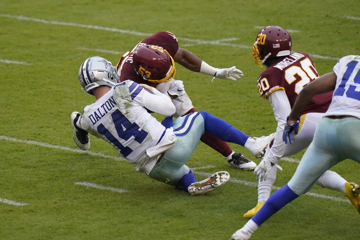Dallas Cowboys quarterback Andy Dalton (14) is hit by Washington Football Team inside linebacke ...