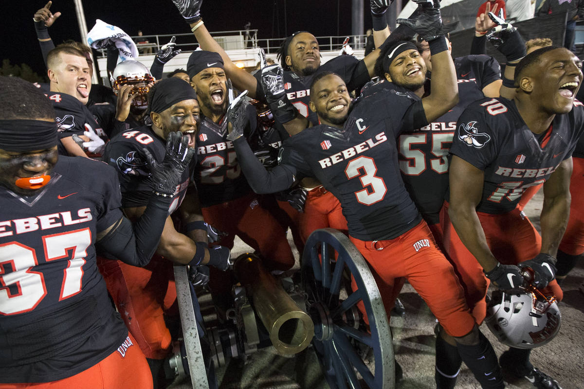 UNLV celebrates with the Fremont Cannon after defeating the Nevada Wolf Pack 34-29 following an ...