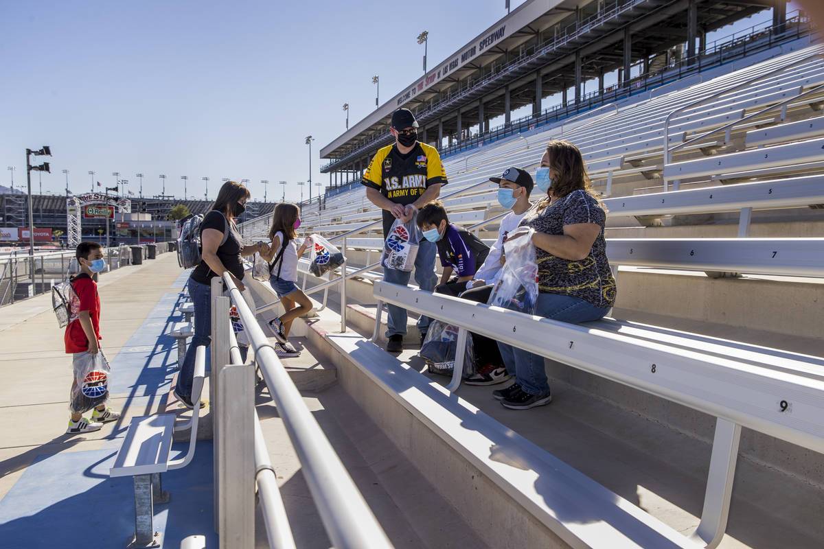 (From left) The Jaramillo and Roberts families enter the stands about the track as the Las Vega ...
