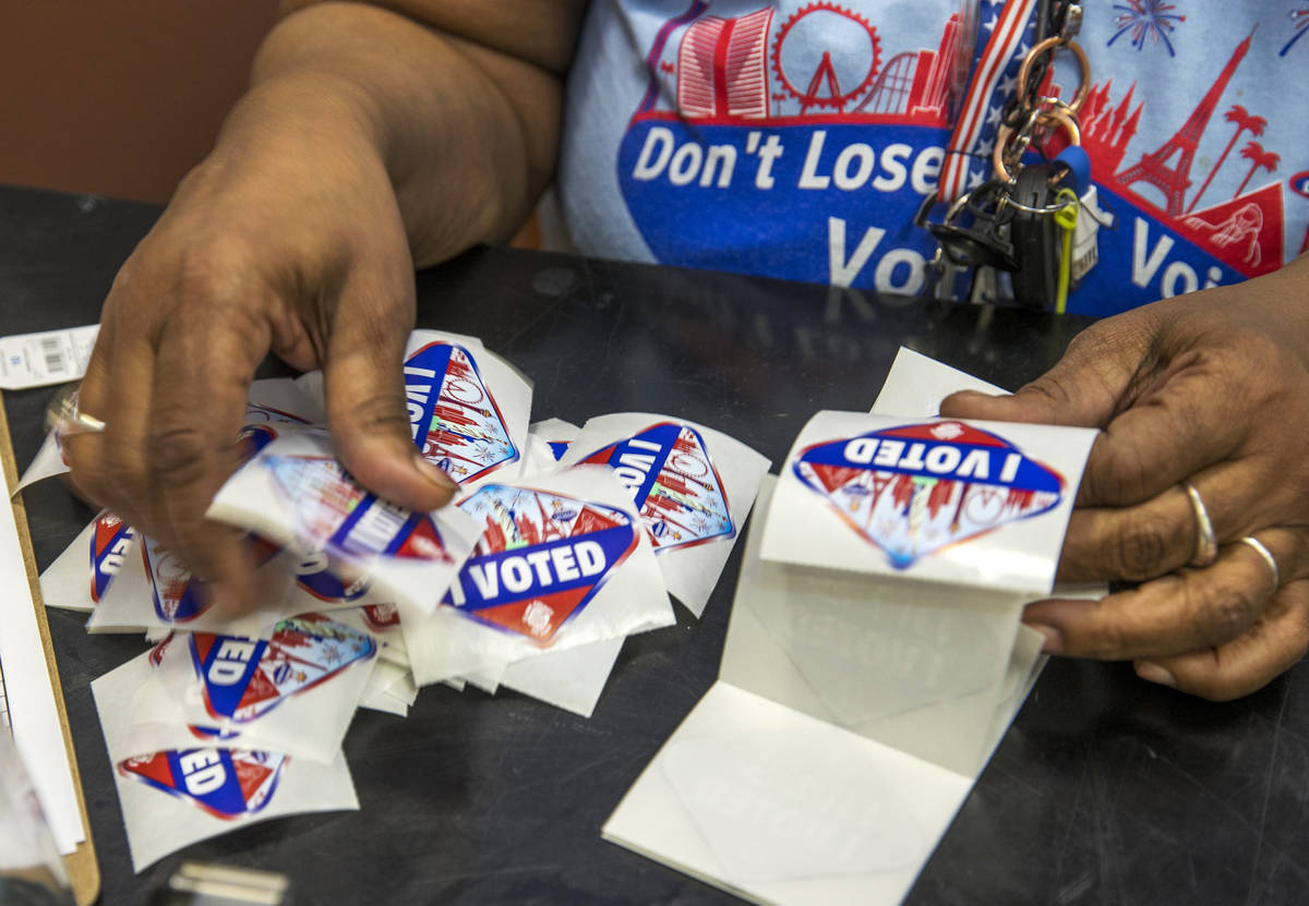 Elections worker Robin Wright readies ÒI VotedÓ stickers for mail-in ballot drop off ...