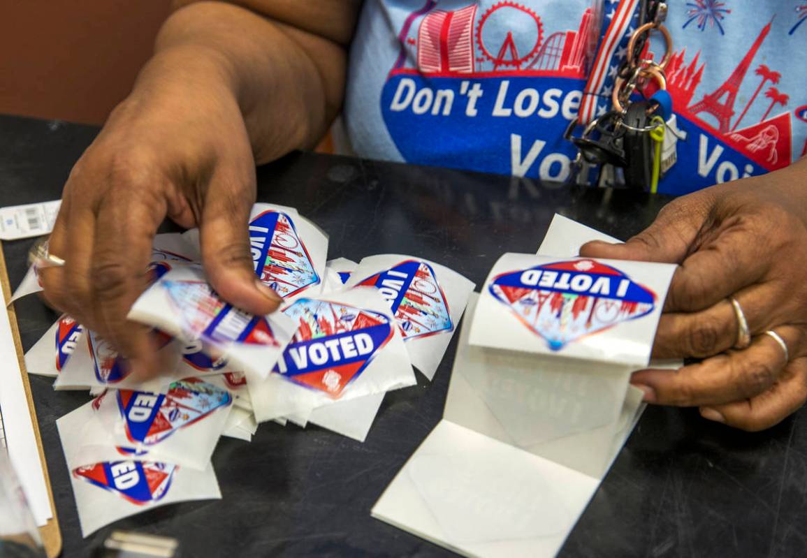 Elections worker Robin Wright readies ÒI VotedÓ stickers for mail-in ballot drop off ...