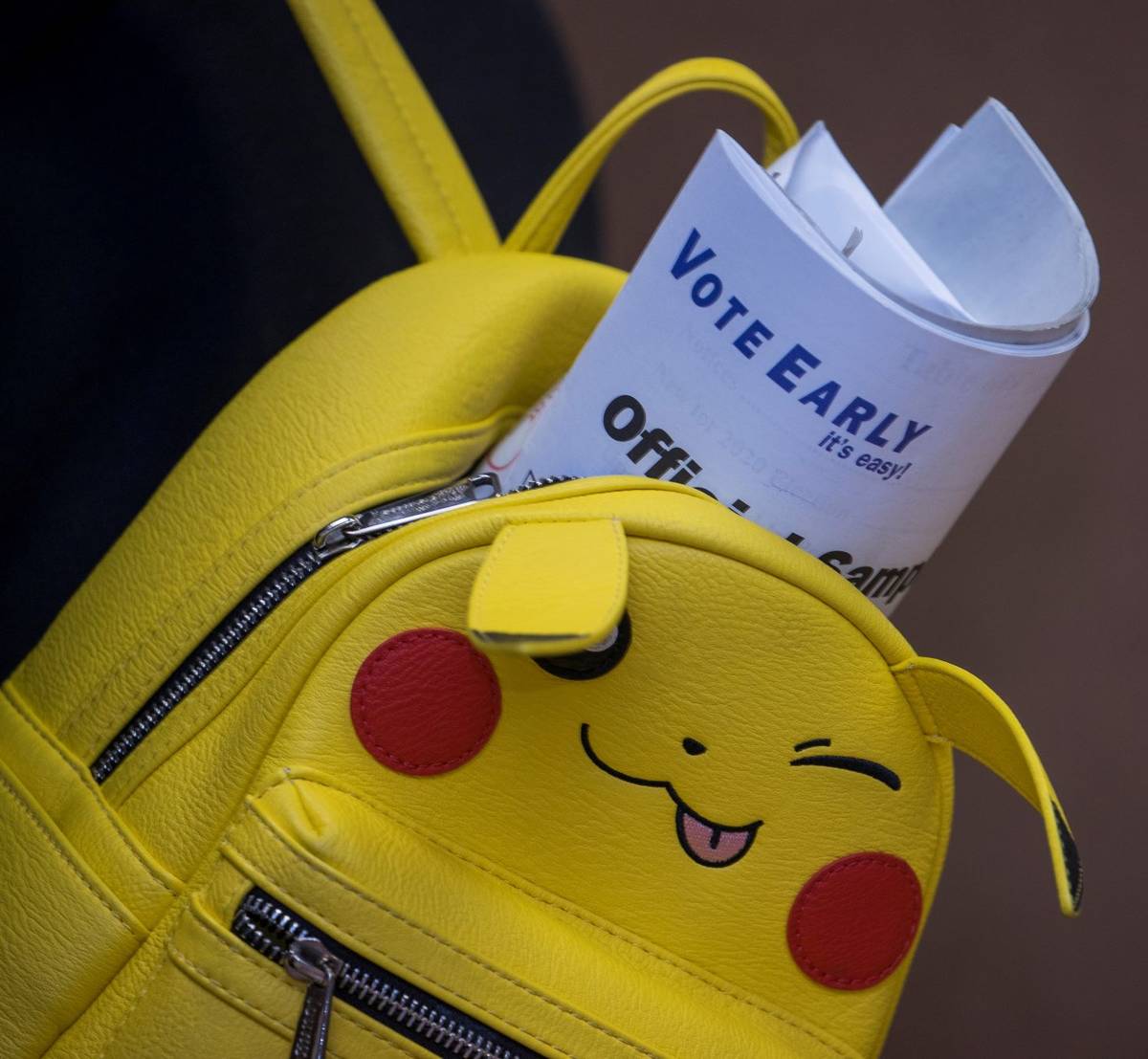 A voter carries an official sample ballot last night of early voting at the East Las Vegas Comm ...