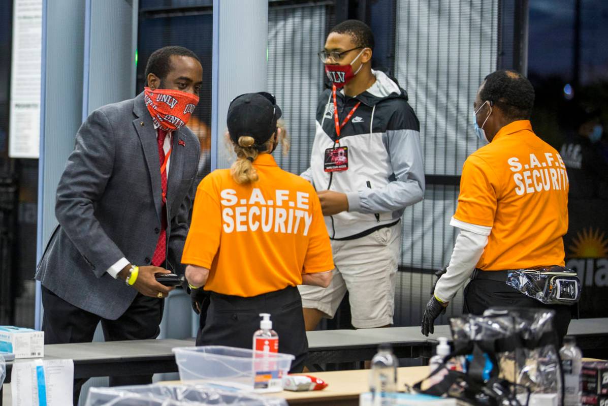 Fans William Wheeler, left, and Lawrence Murray, center, are checked by security as they enter ...