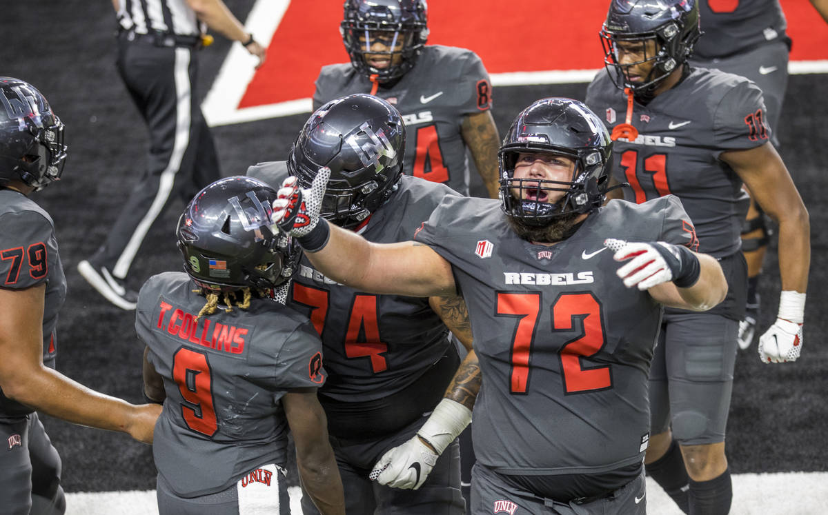 UNLV Rebels offensive lineman Matt Brayton (72) celebrates a touchdown by teammate wide receive ...