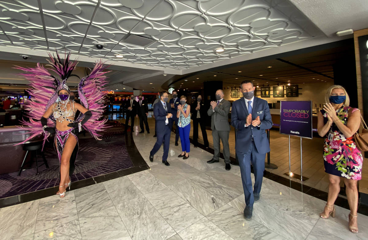 Staff and showgirls greet guests arriving as the doors at Harrah's are open for business again ...