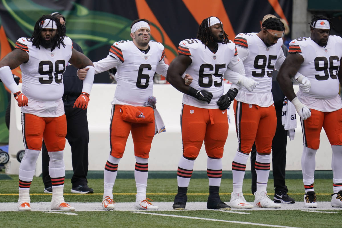 Cleveland Browns quarterback Baker Mayfield (6) locks arms with teammates during the national a ...