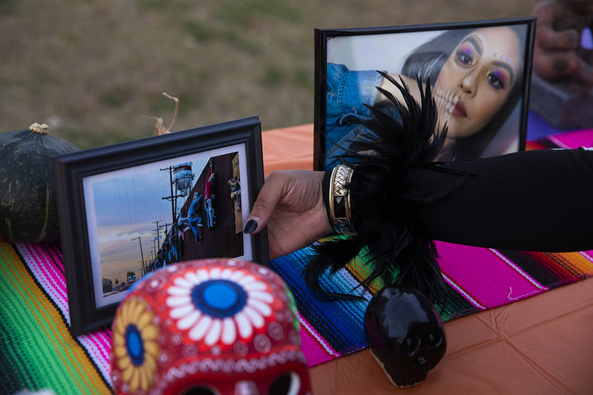 Ingrid ollintzihuatl Moctezuma sets out photos on an ofrenda at a Día de los Muertos event ...
