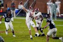 Alabama quarterback Mac Jones (10) passes while being pursued by Mississippi defensive end Ryde ...