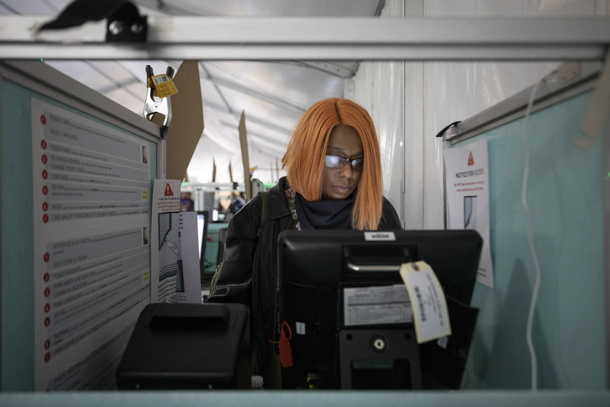 Hollany McKinnis, 41, of Henderson, casts her ballot at the Boulevard Mall polling station minu ...