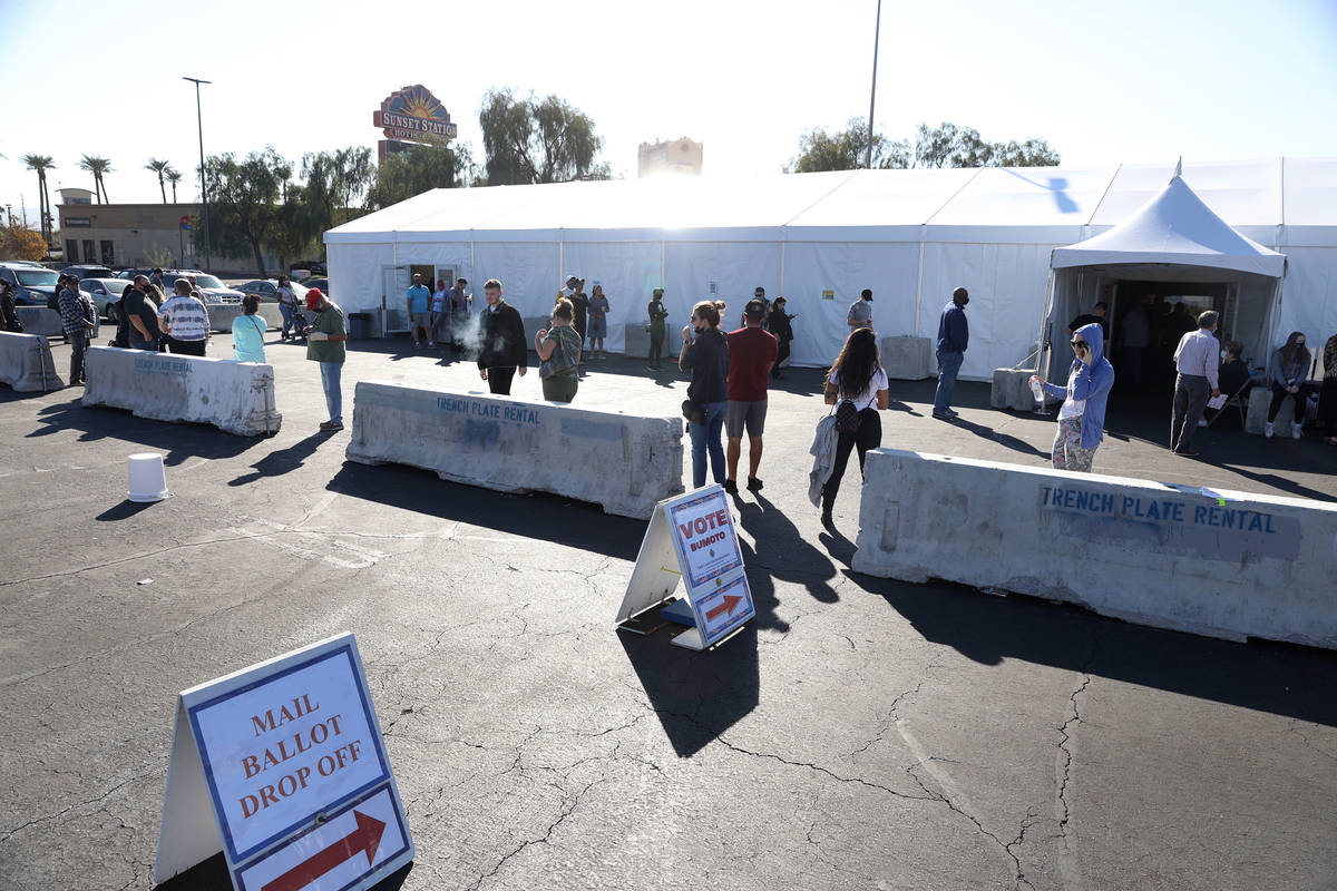 People wait in line to cast their vote at the Galleria at Sunset polling station in Henderson, ...