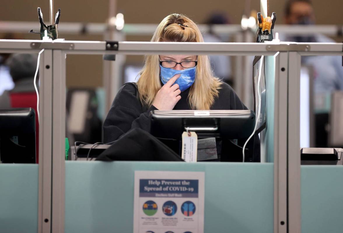 Jennifer McKay of Las Vegas votes at 7:35 a.m. surrounded by empty voting machines at Desert Br ...