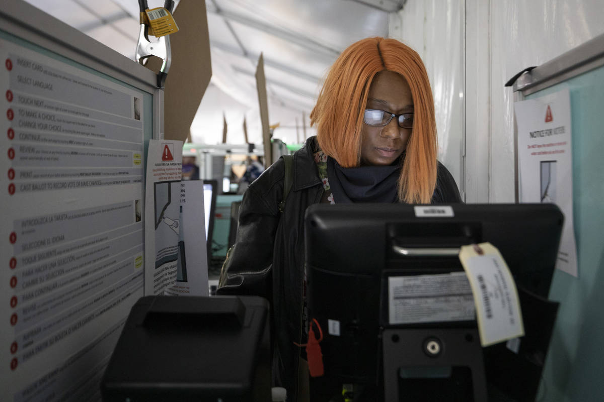 Hollany McKinnis, 41, of Henderson, casts her ballot at the Boulevard Mall polling station min ...