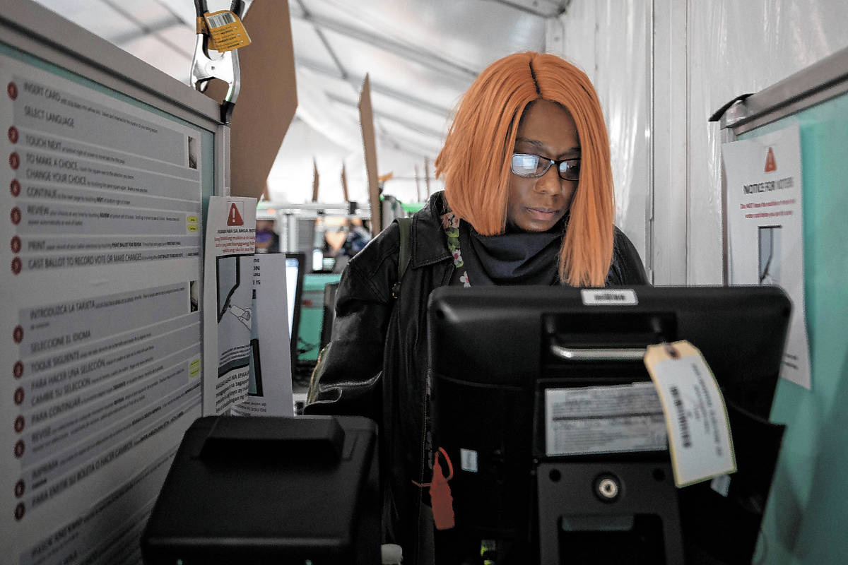 Hollany McKinnis, 41, of Henderson, casts her ballot at the Boulevard Mall polling station min ...