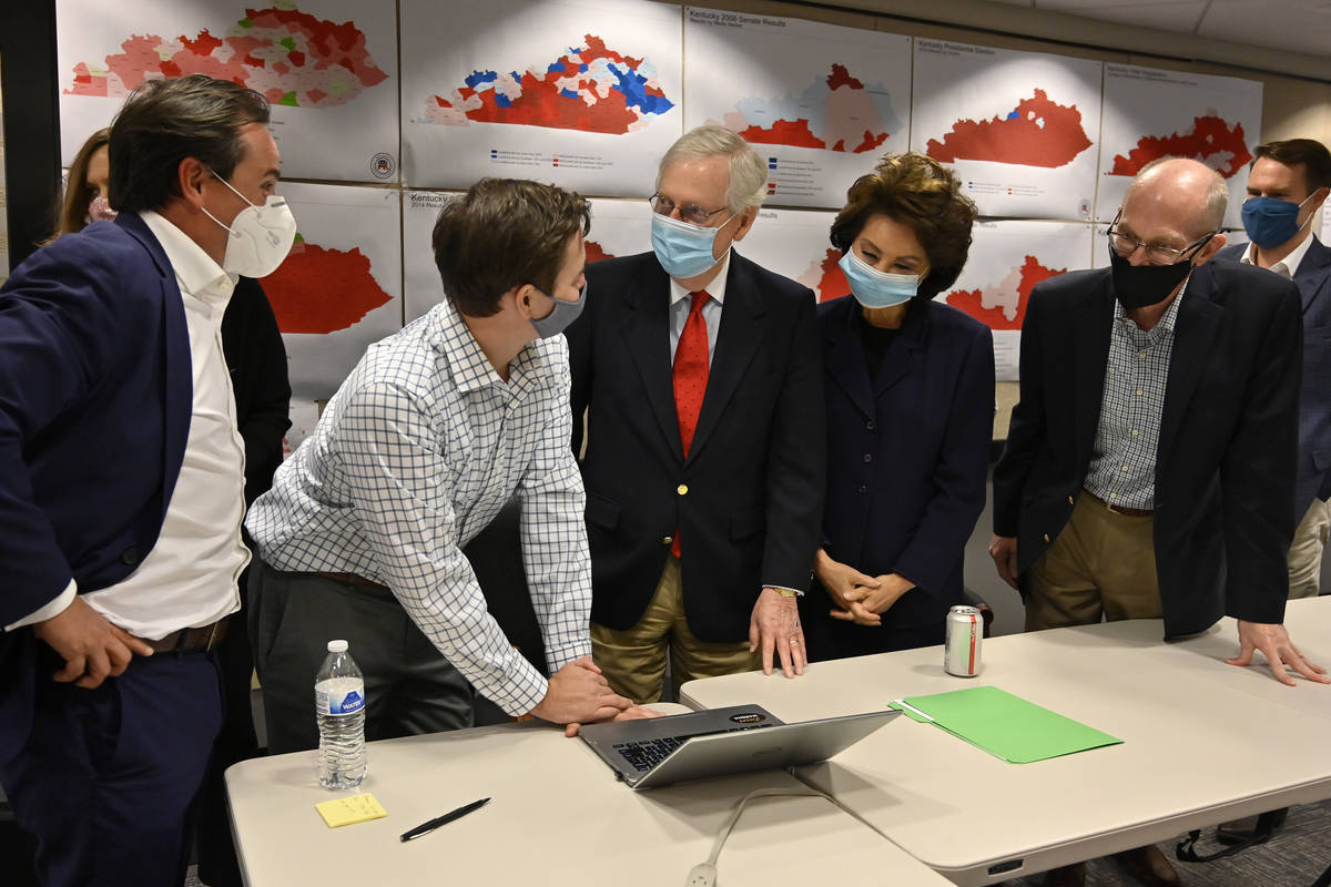 Republican Senate candidate Sen. Mitch McConnell, center, talks with a staff member as they gat ...