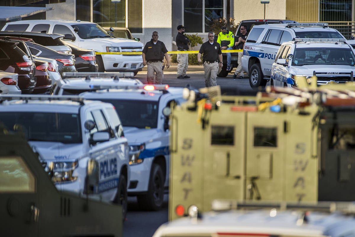 Officers move about outside after four were killed and one injured in police shooting at The Do ...