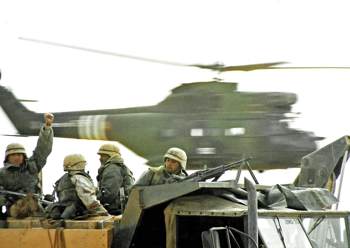 A French Puma helicopter is caught mid-flight behind U.S. troops moving to the Saudi/Iraqi bord ...