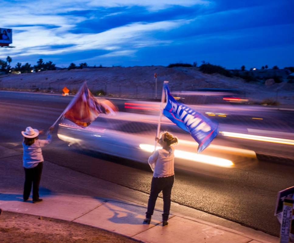 Victoria Giampa and Mary Ann Harden wave President Donald Trump flags along W. Cheyenne Ave. as ...