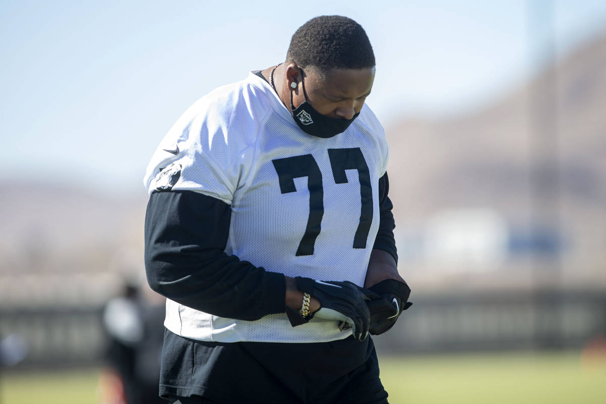 Las Vegas Raiders offensive tackle Trent Brown (77) warms up with a mask on during a practice ...