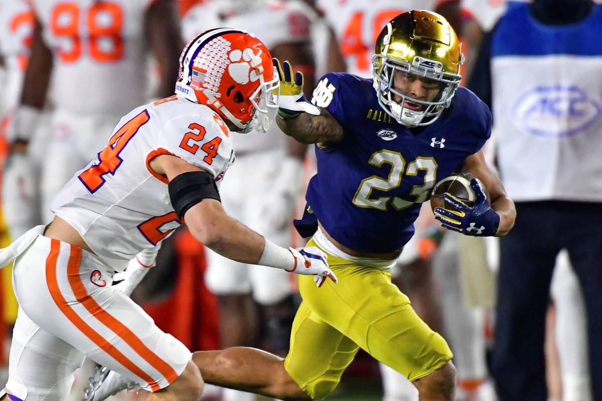 Notre Dame running back Kyren Williams (23) fends off Clemson Tigers safety Nolan Turner (24) o ...