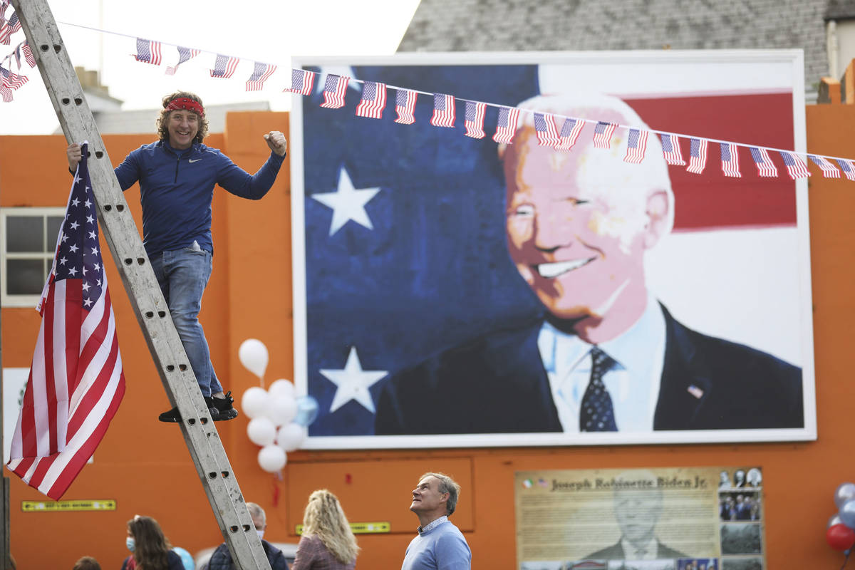 A man puts a US flag up in the town of Ballina, the ancestral home of President-elect Joe Biden ...