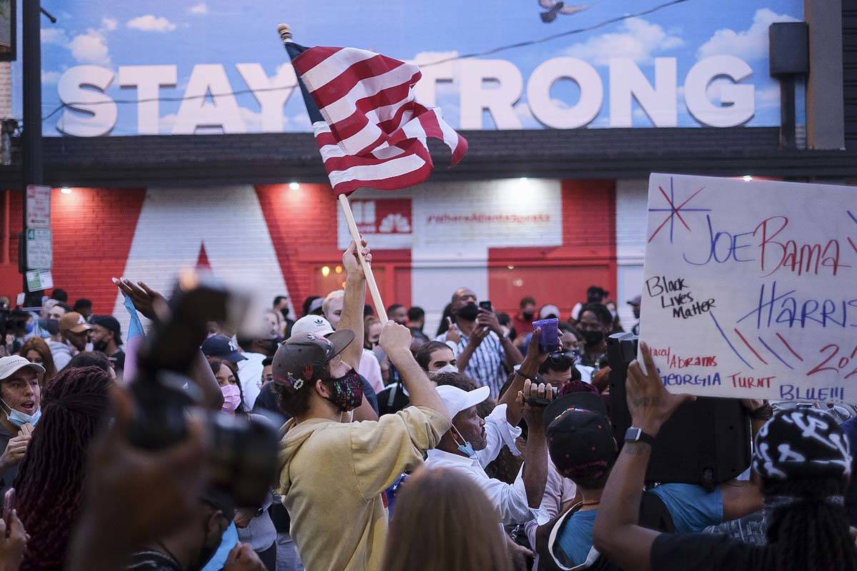 People cheer after the election was called for Joe Biden as they gather to celebrate, Saturday, ...