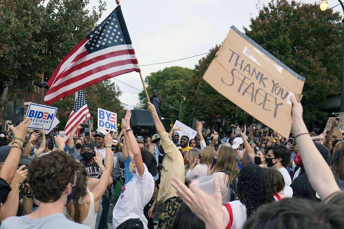 People cheer after the election was called for Joe Biden as they gather to celebrate, Saturday, ...