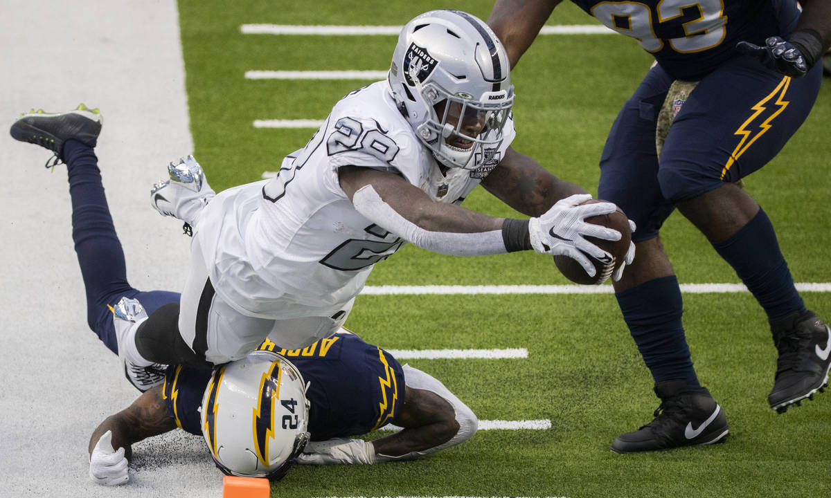 Las Vegas Raiders running back Josh Jacobs (28) leaps into the end zone over Los Angeles Charge ...