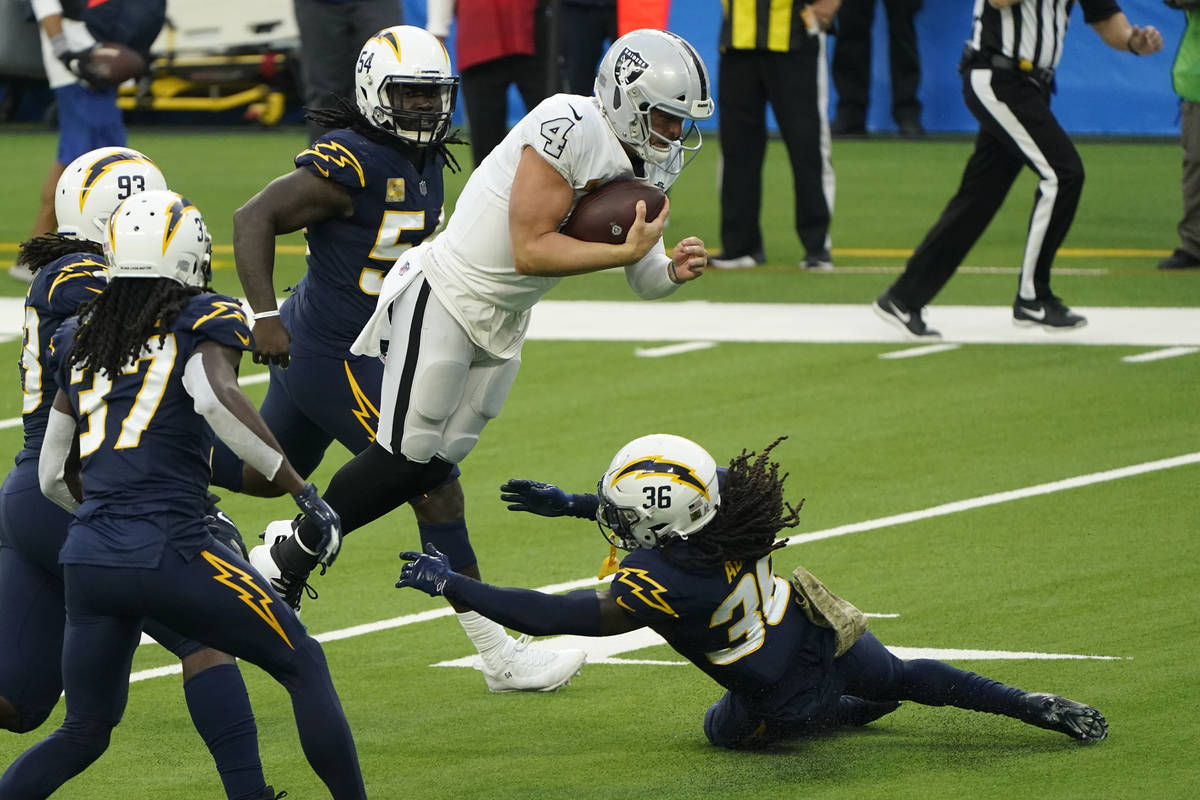 Las Vegas Raiders quarterback Derek Carr leaps over Los Angeles Chargers strong safety Jahleel ...