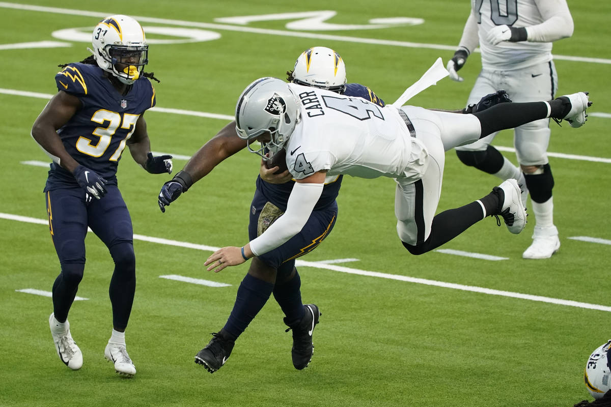 Las Vegas Raiders quarterback Derek Carr leaps over Los Angeles Chargers strong safety Jahleel ...