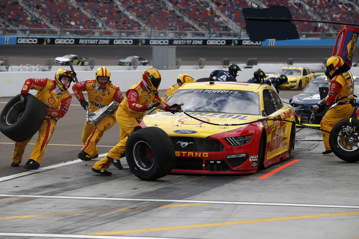 The pit crew for Joey Logano (22) scramble around the car on a pit stop during a NASCAR Cup Ser ...