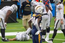 Las Vegas Raiders fullback Alec Ingold (45) remains down surrounded by teammates after Josh Jac ...