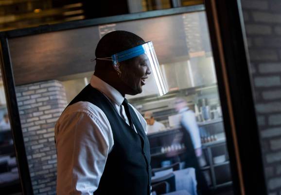 Donald Bailey wears a face shield while serving diners at Nora's Italian Cuisine in Las Vegas o ...