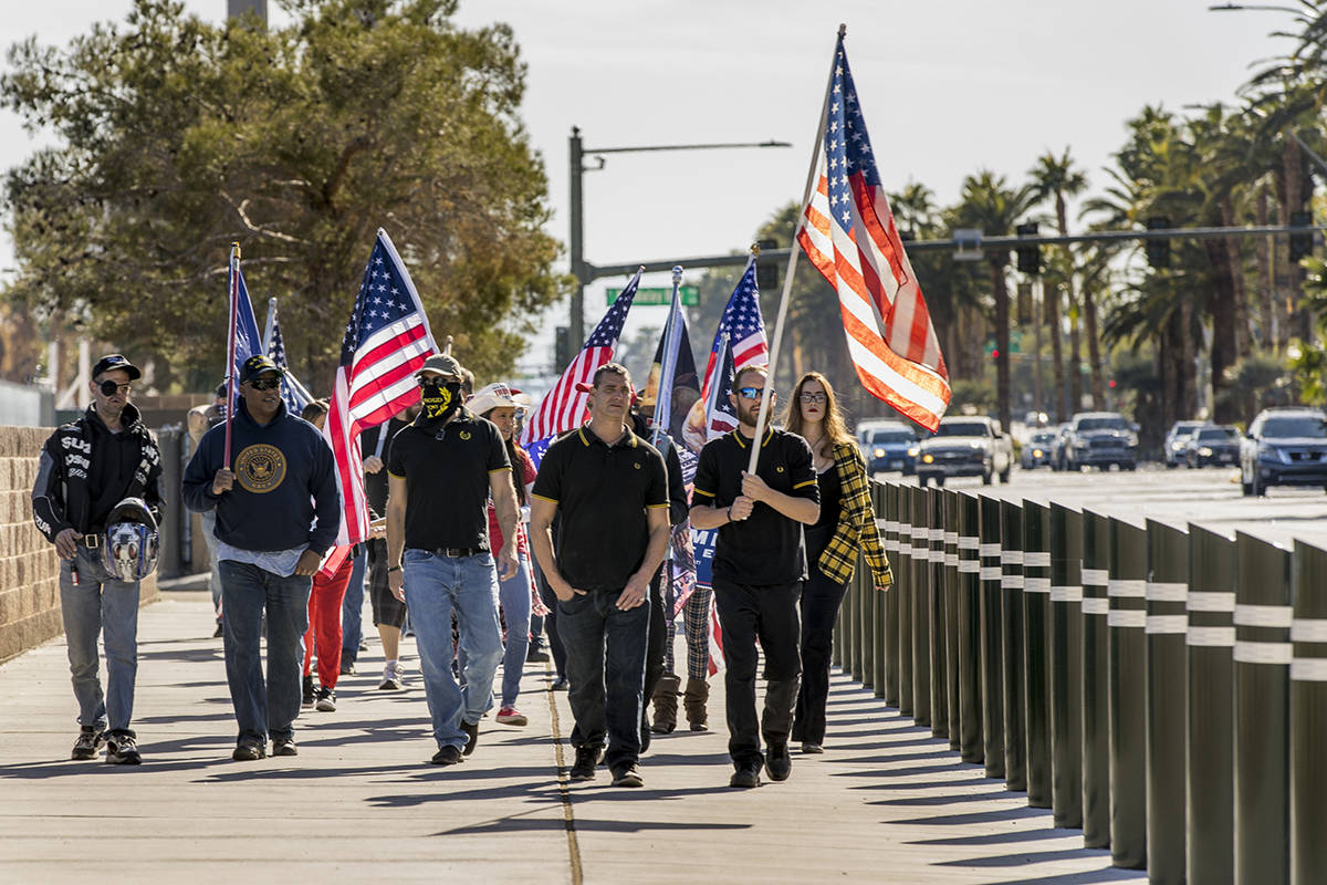 A small group walks south of the Tropicana during a Veterans Day march to peacefully protest Go ...