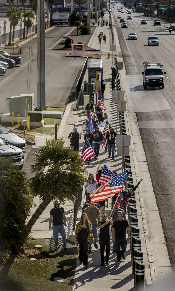 A small group walks past the Tropicana during a Veterans Day march to peacefully protest Govern ...