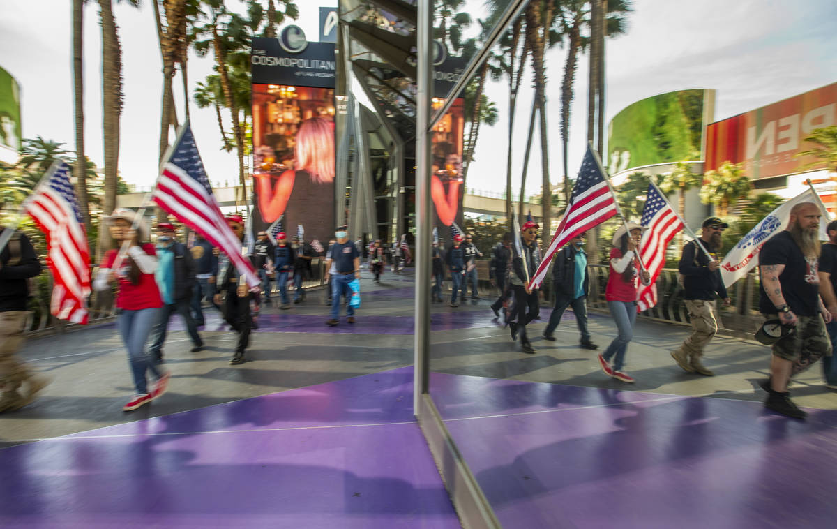 A group moves past The Cosmopolitan during a Veterans Day march to peacefully protest Governor ...