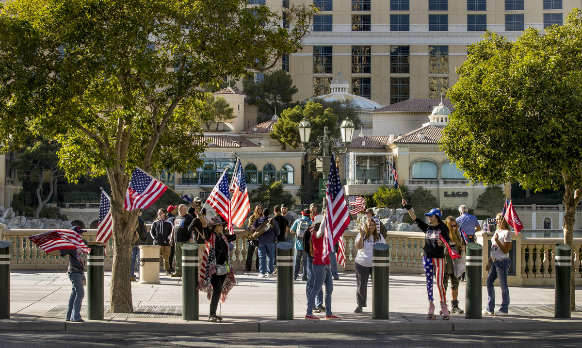 Flag wavers stop in front of the Bellagio during a Veterans Day march to peacefully protest Gov ...